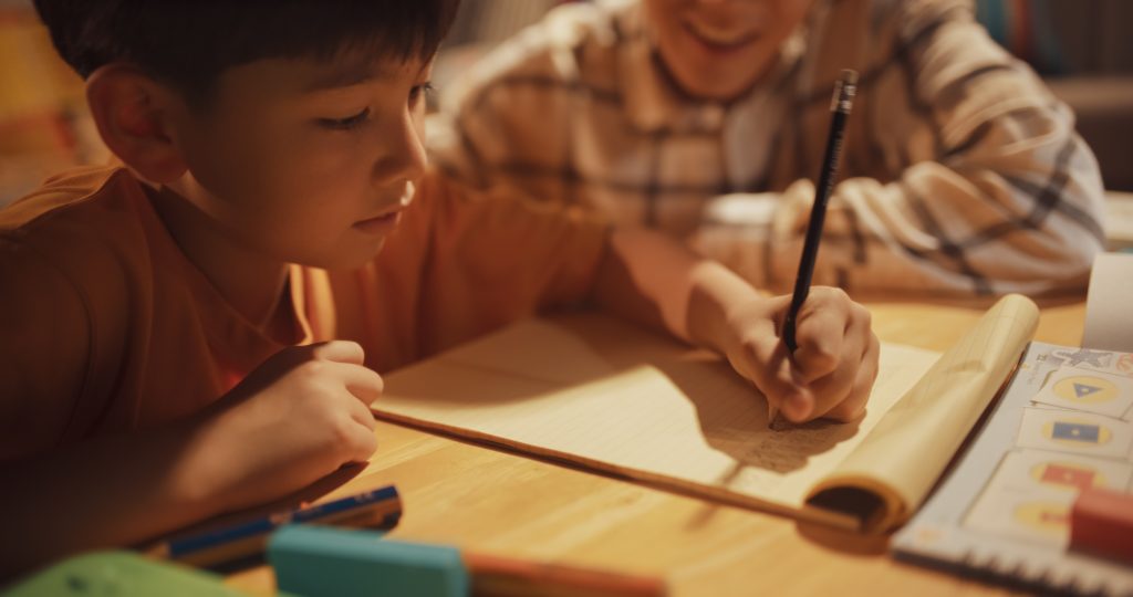 Young boy working with teacher to solve math problem
